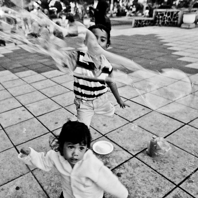 girl and brother playing with bubbles